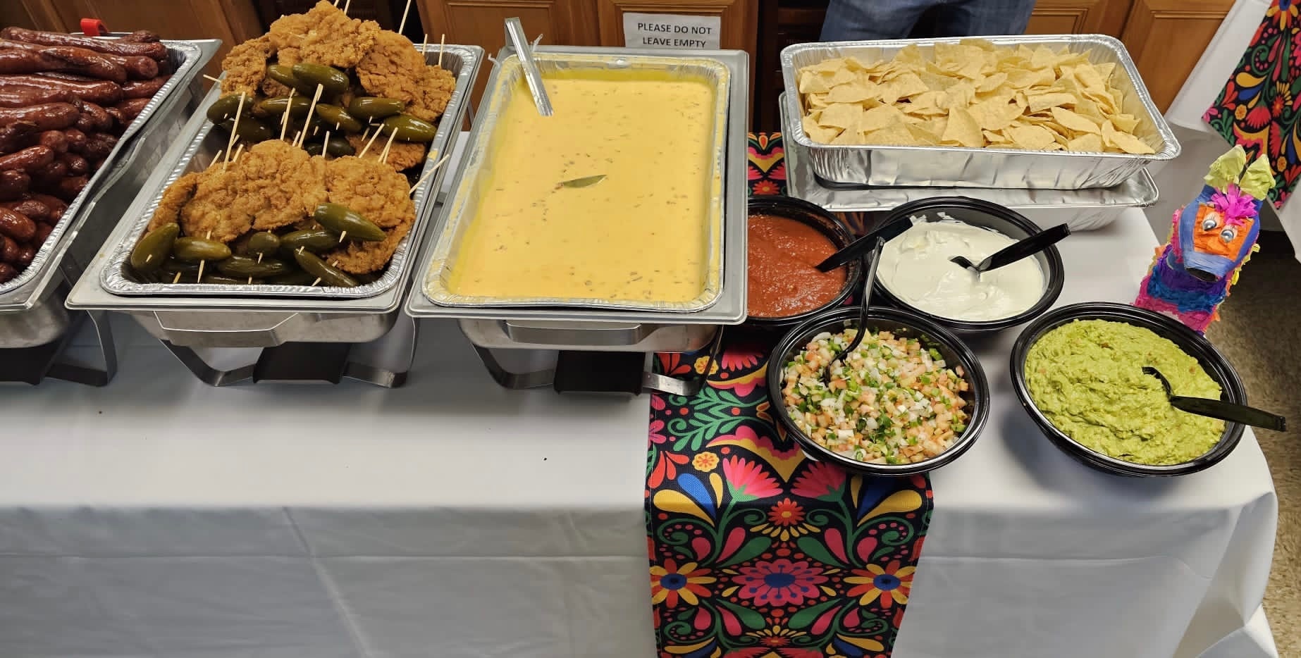 Mia's catering spread with queso, fried chicken, and chips