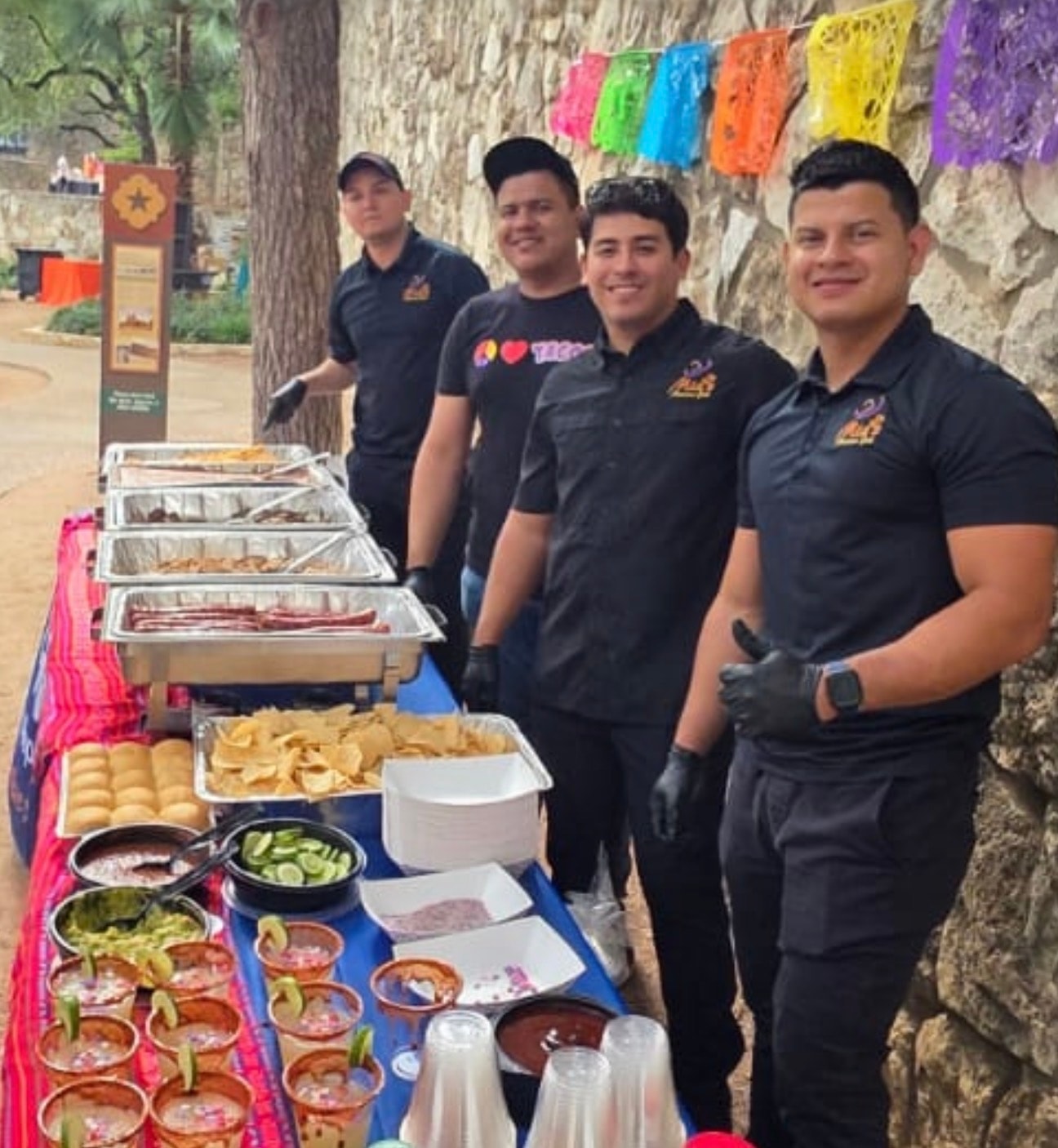 Mia's catering team at outdoor event with full buffet spread