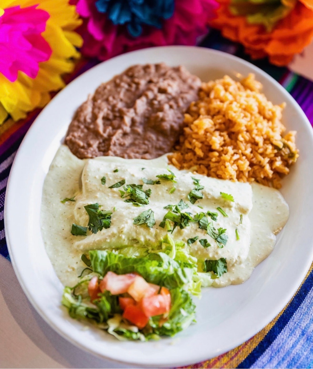 Cilantro cream chicken enchiladas with rice and beans